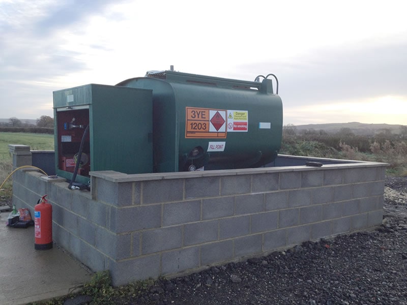 Fuel storage tank with safety labels at Redlands Airfield, Swindon for aviation refueling.