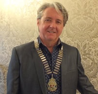 Derek Clark wearing a medal at a formal event, representing leadership in electrical industry.