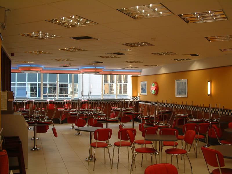 Brightly lit Burger King restaurant in Bristol with red chairs and tables, ready for customers.