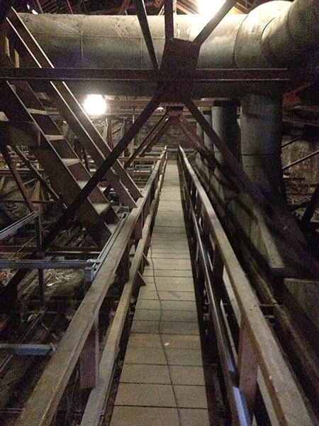 Electrical maintenance walkway inside The Victoria Rooms, Bristol, showcasing industrial lighting an.