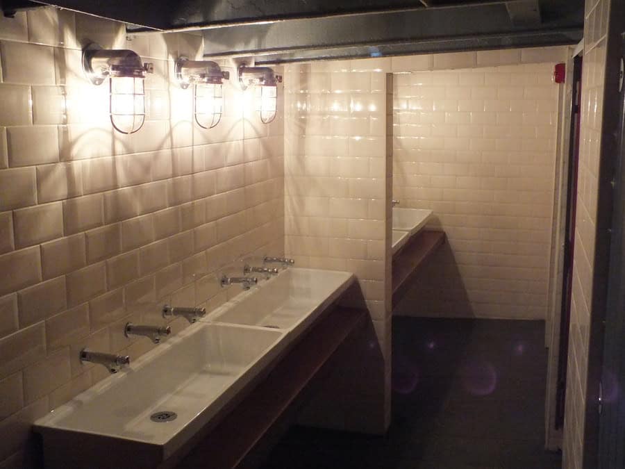Electrical wiring and lighting in a public restroom.